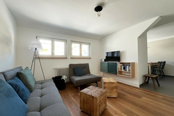 Wohnbereich mit (Schlaf)Sofa, Sessel (Ottomane), Hocker & Tisch aus Weißtanne. TV, Bücher, Spiele, Informationsmaterial